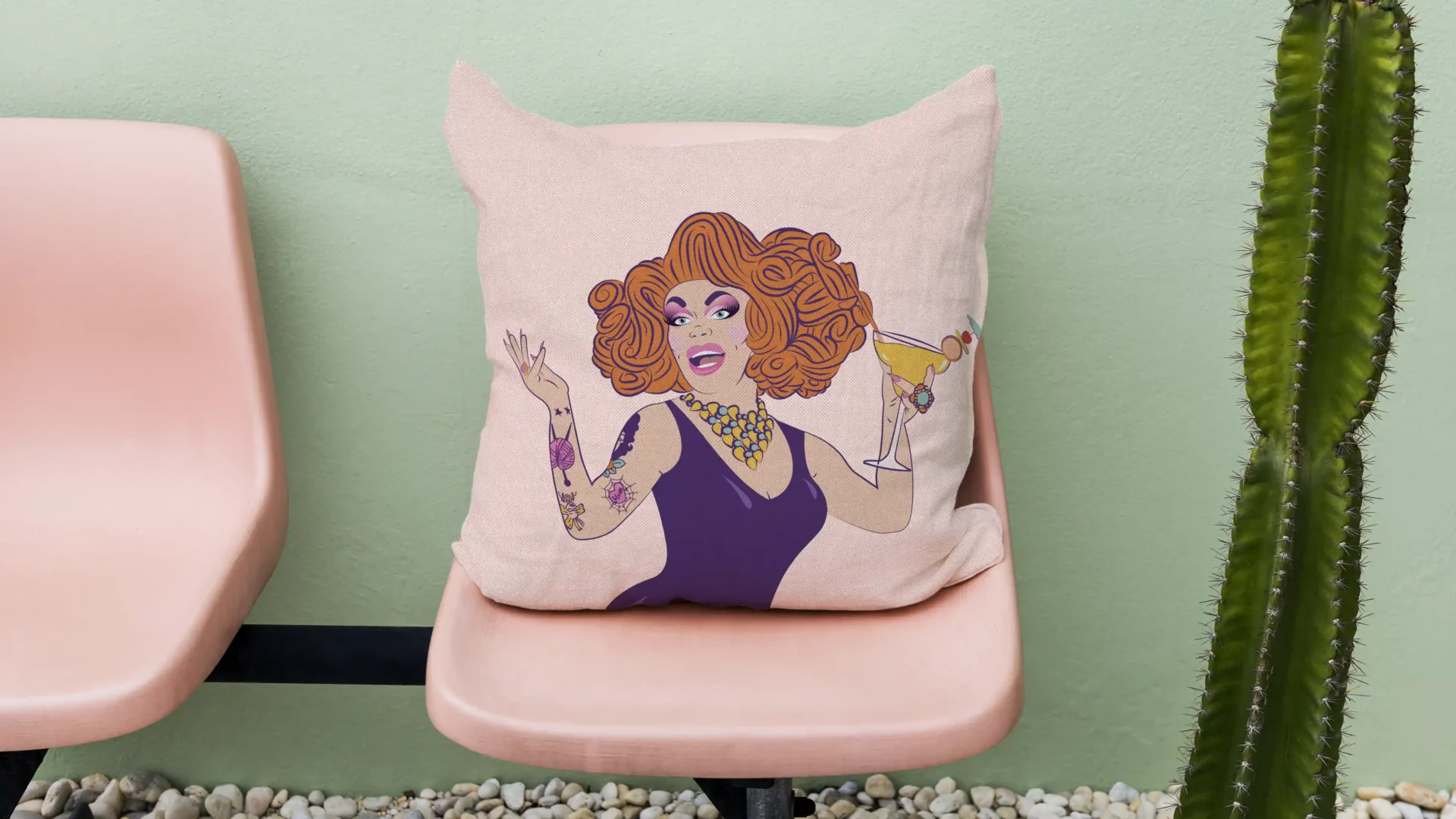 vibrant original festival branding featuring custom illustrations of performer in drag wearing fabulous oversized orange wig and classic lbd, in a stunning shade of purple, holding a summery cocktail and smiling widely. printed on a custom cushion cover sitting on a pink bench seat in a palm springs desert setting.